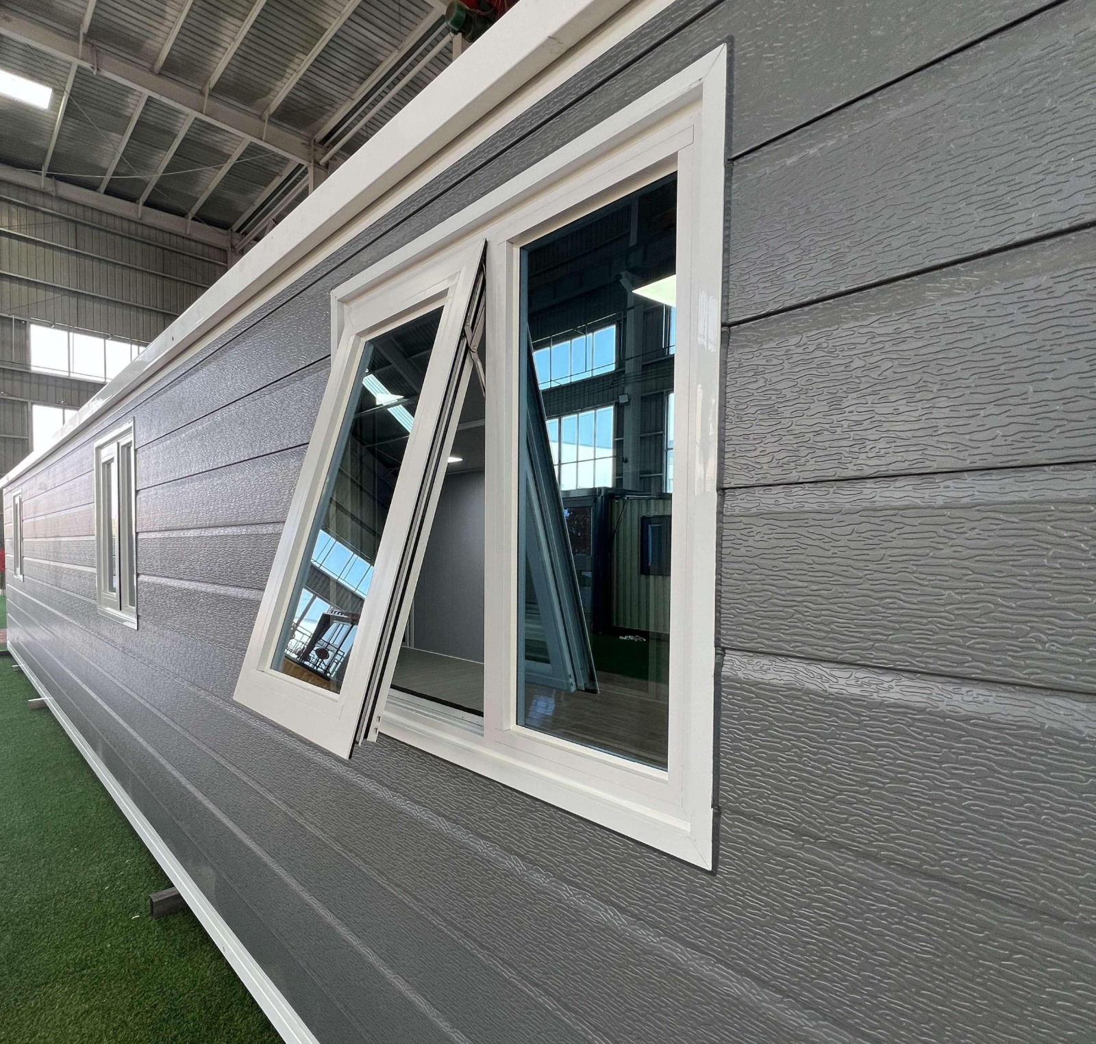 Close-up of exterior cladding and awning window detail on the factory floor