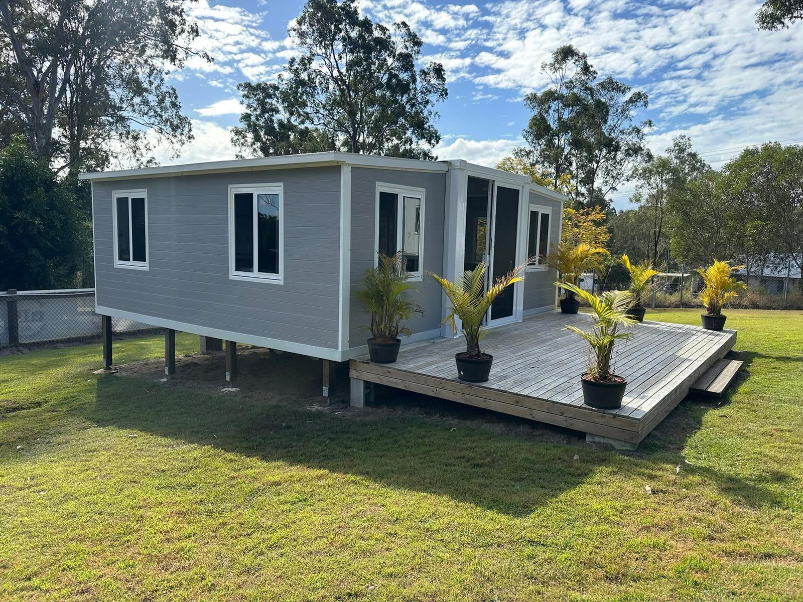 A real Eco Nest House installed on stumps on a residential block in Queensland, with deck and landscaping